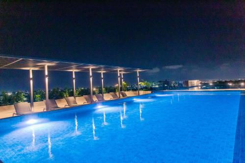 a large swimming pool with lounge chairs at night at Accra Luxury Apartments @ The Lennox in Accra