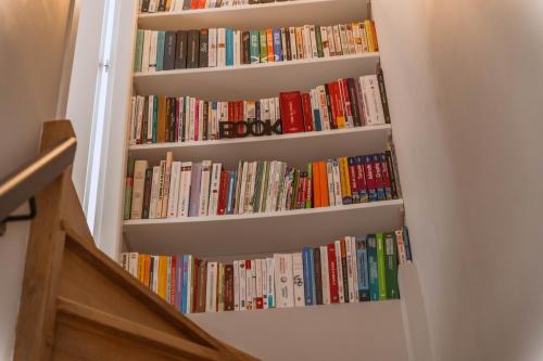 a book shelf filled with books in a room at Villa de Charme avec Piscine Calme & Élégance in Aubenas