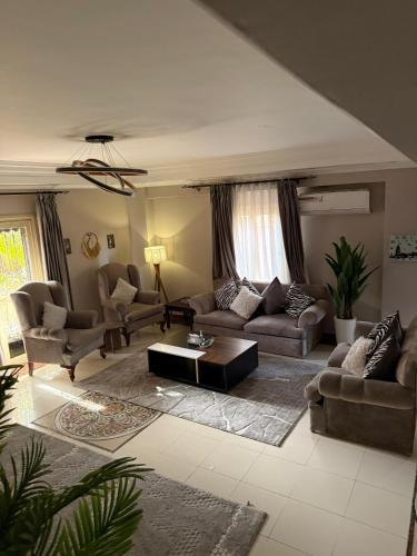a living room with couches and a coffee table at فيلا مبهجة مع مسبح وحديقة رائعة in 6th Of October
