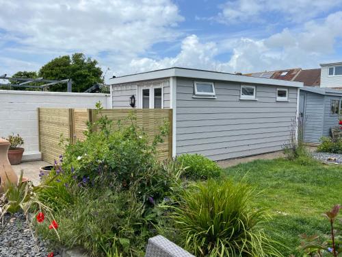 a garden with a small garage next to a fence at Shoreham Chalet in Shoreham-by-Sea