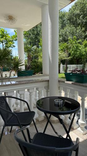 a patio with two chairs and a table on a porch at Frenki'S Residence in Velipojë