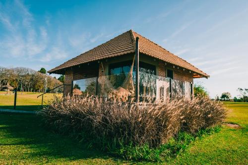 a small building in a field with tall grass at Virá Charme Resort in Fernandes Pinheiro