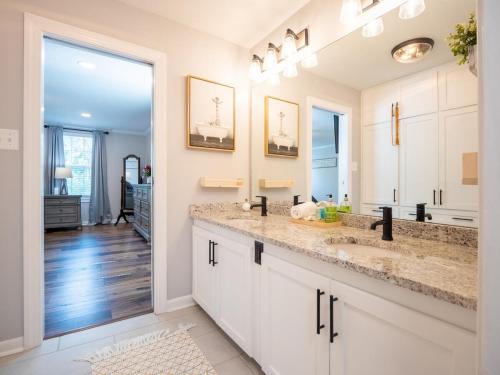 a kitchen with two sinks and a large mirror at Luxury At Meadowbrook, Pool Home, Fire Pit, Fort in Valdosta