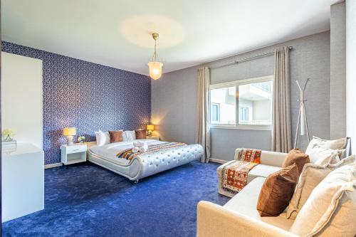 a bedroom with a bed and a couch at Modern Oasis - Elegant Cave - Family Heaven - Designer's Paradise - 10 min away from Abu Dhabi Airport, Yas Island, Formula 1, Ferrari World, SeaWorld, Warner Bros World in Abu Dhabi