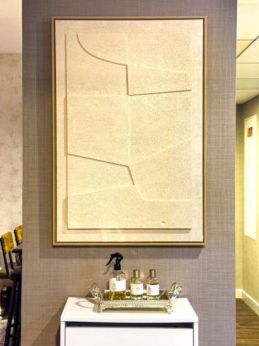 a painting on a wall above a white table with candles at Modern Oasis - Elegant Cave - Family Heaven - Designer's Paradise - 10 min away from Abu Dhabi Airport, Yas Island, Formula 1, Ferrari World, SeaWorld, Warner Bros World in Abu Dhabi