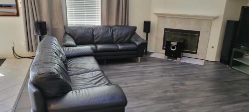 a living room with a leather couch and a fireplace at Luxury 2 Bed 1 Bath Fully Private in Chula Vista