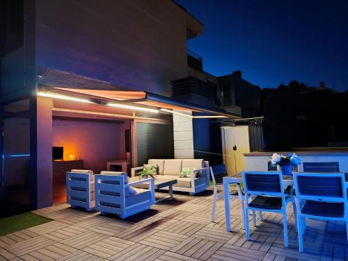 a patio with blue and white chairs and a table at Ático Chill-Out de lujo con piscina y garaje gratis in Vigo
