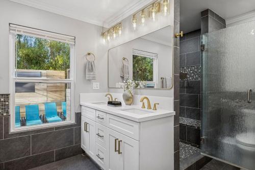 a white bathroom with a sink and a shower at NEW LUXURY ESTATE - Sleeps 22 - Saltwater Pool, Spa, Waterfall With Cave Grotto! in Vista