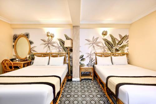 une chambre d'hôtel avec deux lits et un miroir dans l'établissement Spring House Saigon central park, à Hô-Chi-Minh-Ville