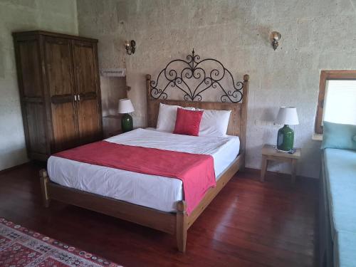 a bedroom with a large bed with a red blanket at Kemerli House in Avanos
