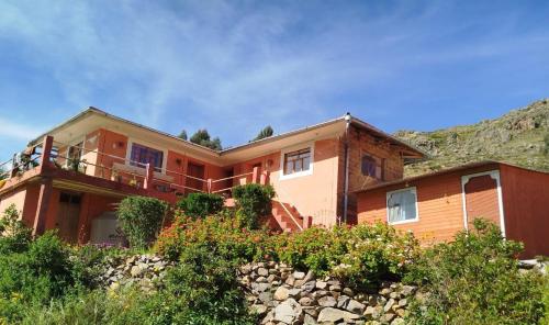 a large house with a hill in the background at Amantaní Elisa's lodge Puno in Puno