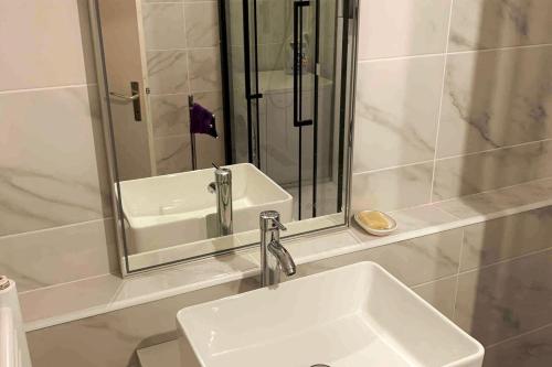 une salle de bain avec un lavabo blanc et un miroir dans l'établissement 13th floor apartment with covered parking, à Vandœuvre-lès-Nancy