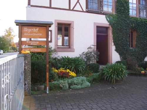 a sign in front of a building with flowers at Gästehaus Brunhilde in Wittenweier