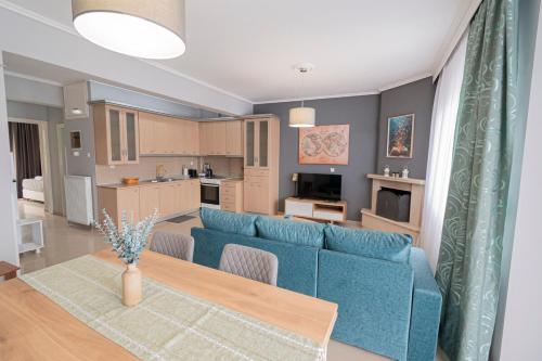 a living room with a blue couch and a table at M&P Apartment by RentalsPro - Nea Moudania Halkidiki in Nea Moudania