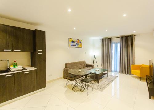 a kitchen and living room with a table and a couch at Accra Luxury Apartments @ The Lennox in Accra
