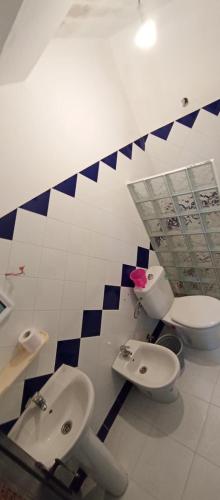 a bathroom with two toilets and two sinks in it at Dar Bouanani in Asilah