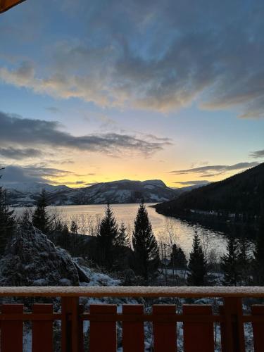 a view of a lake at sunset from a house at Maxi Cabin with Sauna and Jacuzzi in Kovan