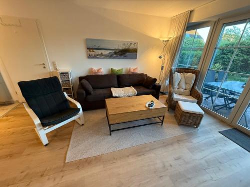 Una sala de estar con un sofá y sillas y una mesa. en Ferienwohnung Strandoase, en Schönberger Strand
