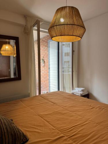une chambre avec un grand lit avec une grande fenêtre dans l'établissement Ayacucho loft, à Córdoba