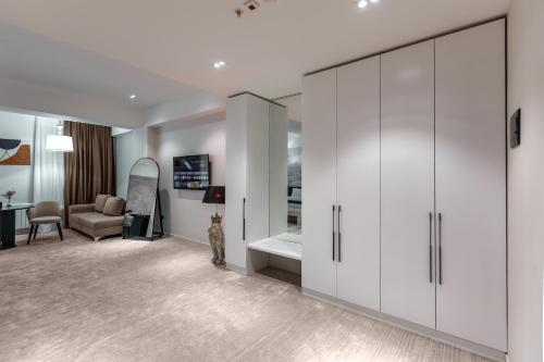 a living room with white cabinets and a cat in a room at Monte Napoleone Hotel in Baku