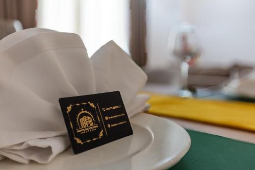 a book sitting on top of a plate on a table at Monte Napoleone Hotel in Baku