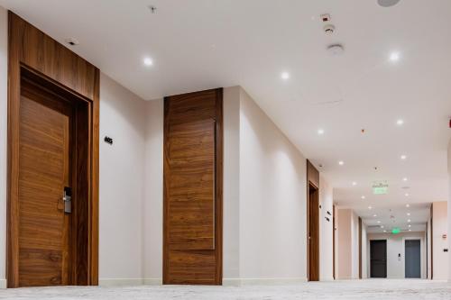 a hallway with wooden doors in a building at Monte Napoleone Hotel in Baku