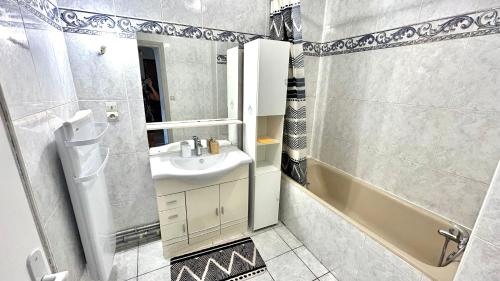 une salle de bain avec un lavabo et une baignoire dans l'établissement T3 Cosy Coeur Aix Les Bains avec 2 Balcons, à Aix-les-Bains