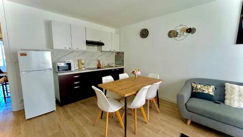 - une cuisine et une salle à manger avec une table et un canapé dans l'établissement T3 Cosy Coeur Aix Les Bains avec 2 Balcons, à Aix-les-Bains