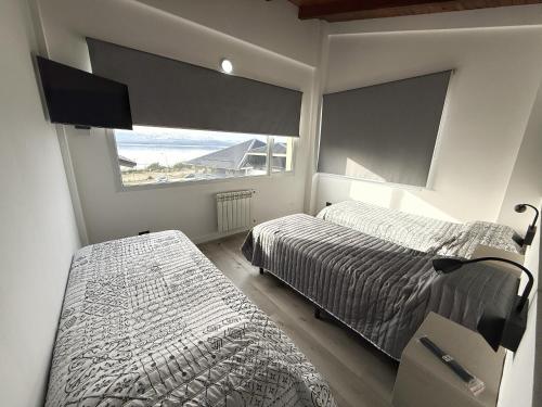 a bedroom with two beds and a window at Las Victorias Suites Bariloche in San Carlos de Bariloche