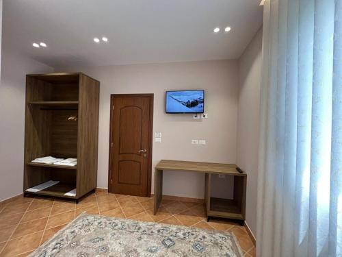 a room with a door and a television on the wall at Vila ENSO in Berat