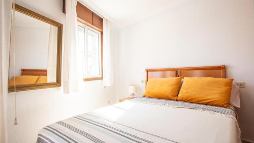 a bedroom with a bed and a mirror at Casa Marinera en A Guarda in A Guarda