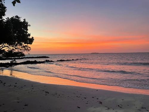 a sunset on a beach with the ocean at Hotel Carey Beach Baru in Baru