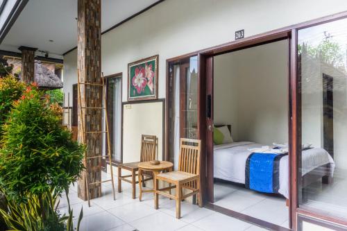 a room with a bedroom and a bed and a balcony at Bali Laksita Homestay in Canggu