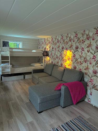 a living room with a couch and a bed at Seaside Escape Cozy Cottage 2 Min from the Beach in Halmstad