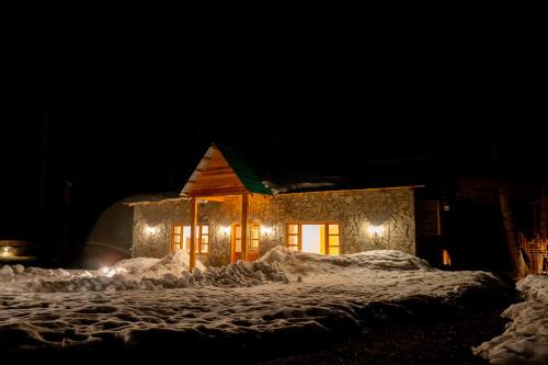 a house covered in lights in the snow at night at Celine Resorts Kumrat Valley in Tāl