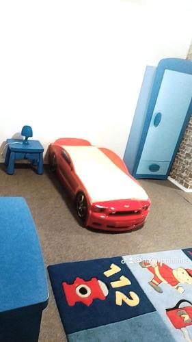 a red toy car sitting on the floor next to a table at Haval in Idar-Oberstein