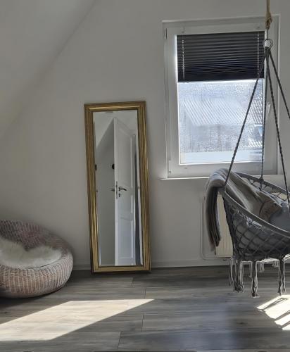 a mirror and a hammock in a room with a window at Schäferhaus in Wolfsburg