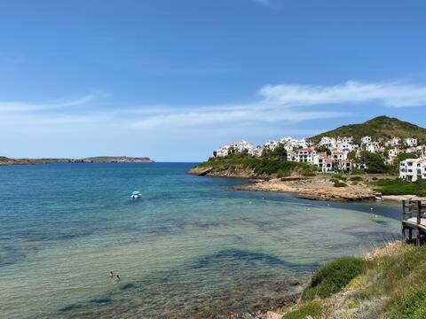 a large body of water with houses and a town at Miravent Terraza y Jardin Frente al mar Menorca in Fornells