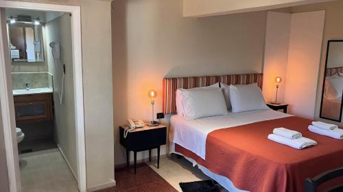 a hotel room with a bed and a bathroom at Casa Alta Hotel Boutique & Spa - Solo Adultos in Villa Carlos Paz