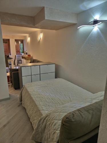 a bedroom with a bed and a desk and a kitchen at Ermi Apartment Temù in Temù