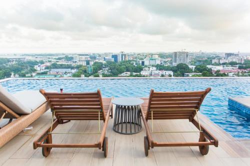 two chairs and a table on a deck overlooking the water at Accra Luxury Apartments at Kass in Accra