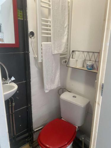 une salle de bain avec des toilettes rouges et un lavabo dans l'établissement Entire Studio Downtown, Old Port, à Marseille