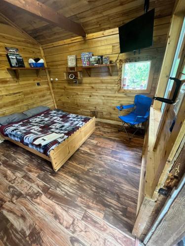a bedroom with a bed and a chair in a room at Bass Farm Twin Lakes Couples Dry Cabin in Wasilla