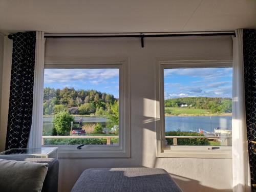 a room with two windows with a view of a lake at Trevligt fritidshus med underbar utsikt in Gothenburg
