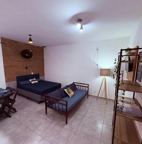 a living room with a bed and a couch at Studio Vista Linda 2 - Acesso a Riviera e Centro Kitnet in Bertioga