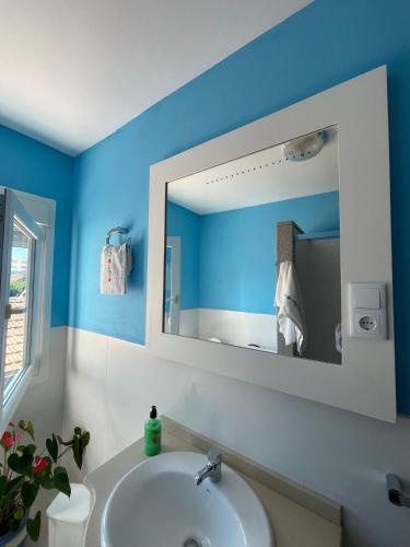 a bathroom with a white sink and a mirror at Apartamento céntrico Playa de Carnota in San Mamede de Carnota