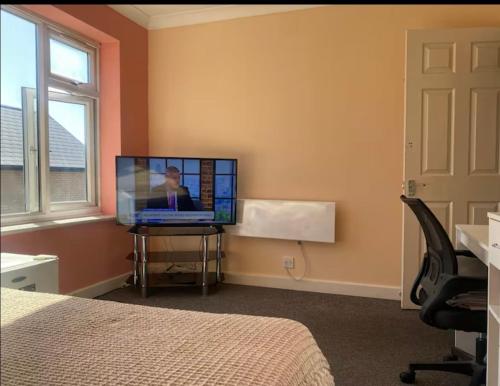 Un dormitorio con una cama y un televisor sobre una mesa. en Coven, en Moffat
