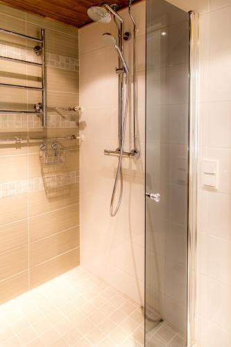 a shower with a glass door in a bathroom at Apartments Rovakatu C19 in Rovaniemi