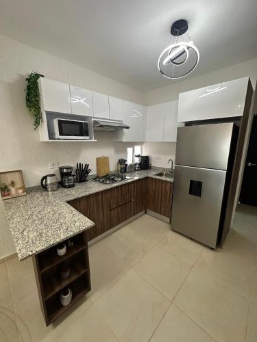 a kitchen with a stainless steel refrigerator and cabinets at Departamento Orion 3 rooms planta baja en Cancun by EITA in Cancún