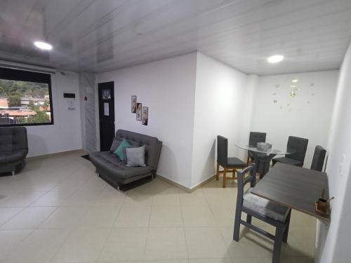 a living room with a couch and a table and chairs at Hospedaje samfer in Envigado